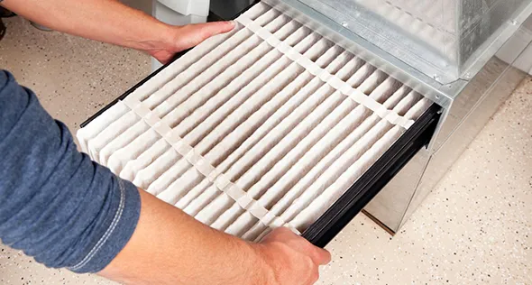 Close-up of a new HVAC air filter being installed, demonstrating quality maintenance practices for optimal HVAC performance.
