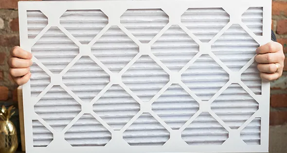 Professional technician upgrading an HVAC air filter in Reno, NV, showcasing the importance of efficient air filtration for indoor air quality.