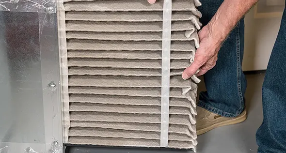Technician replacing an air filter in Sun Valley, NV, highlighting professional air filter replacement services for HVAC systems.